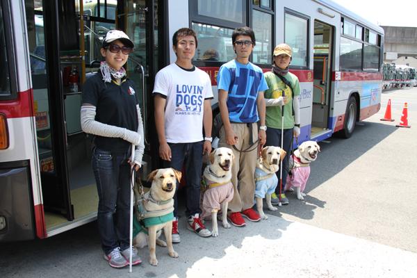 バスの前で記念撮影をする訓練士4人とそれぞれの訓練犬