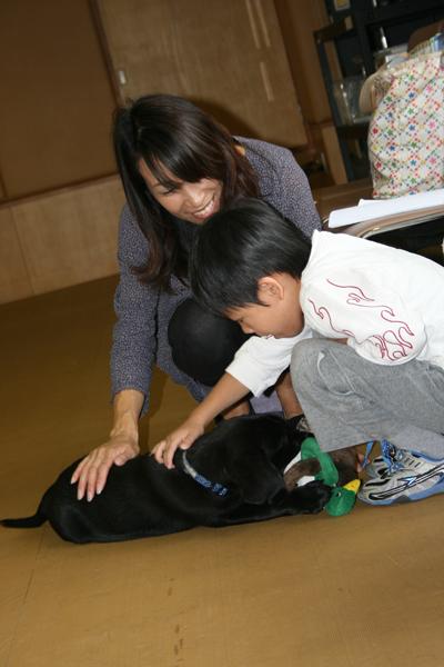 黒いパピーをお母さんと一緒になでる男の子